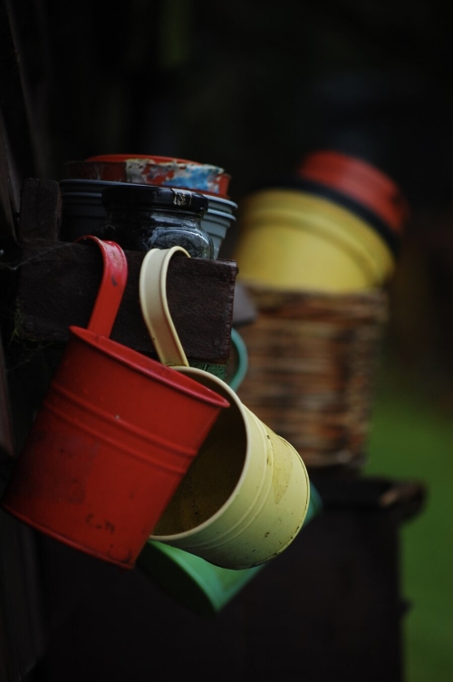 Old, brightly coloured hanging plant pots.